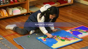 Niña explorando material Montessori de geografía