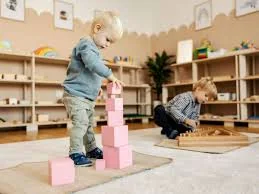 Niños construyendo con bloques en ambiente Montessori